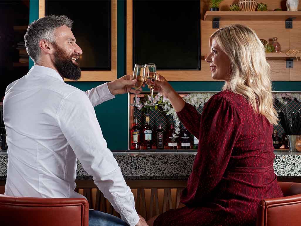 Couple drinking prosecco at a bar